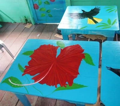Upcycled hand painted tables with tropical birds and plants in Bocas del Toro. 