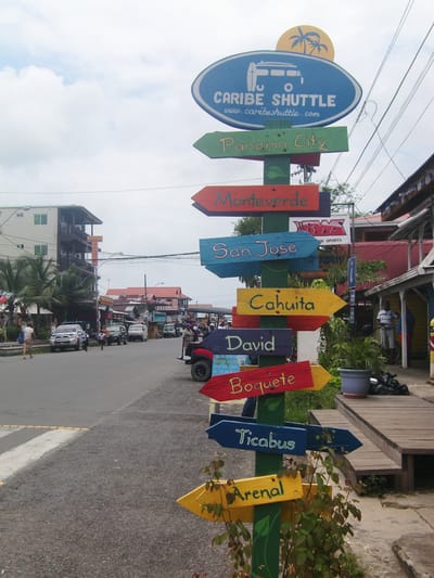 Hand painted sign with arrow pointers in Bocas del Toro. 