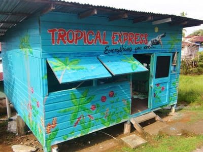 Brightly coloured restaurant with hand painted tropical design and lettering. 