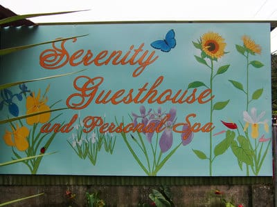 Hand painted guesthouse sign with flowers.