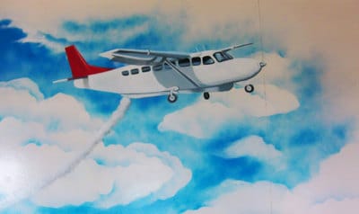 Spraycan mural of aircraft and clouds in Bocas del Toro.